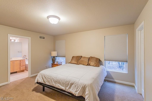 8121 Hitchcock Rd Unit 11, Boardman, OH 44512 - bedroom with light carpet, connected bathroom, and a textured ceiling