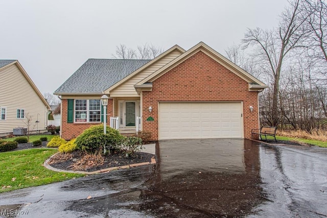 8121 Hitchcock Rd Unit 11, Boardman, OH 44512 - view of front of property featuring driveway, brick siding, an attached garage, and roof with shingles