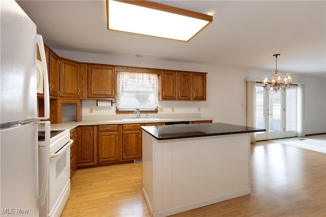 189 Park Place Dr, Wadsworth, OH 44281 - kitchen featuring white appliances, light wood finished floors, brown cabinetry, and a chandelier