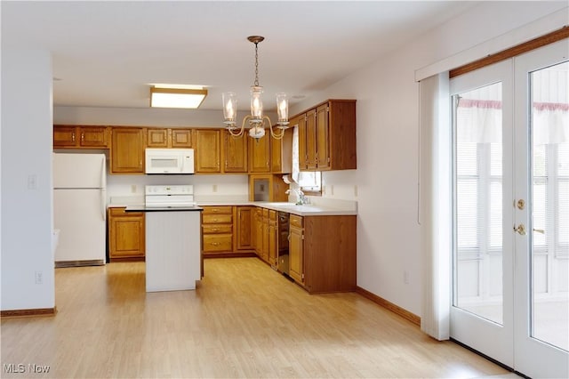 189 Park Place Dr, Wadsworth, OH 44281 - kitchen featuring white appliances, a chandelier, light wood finished floors, and brown cabinetry