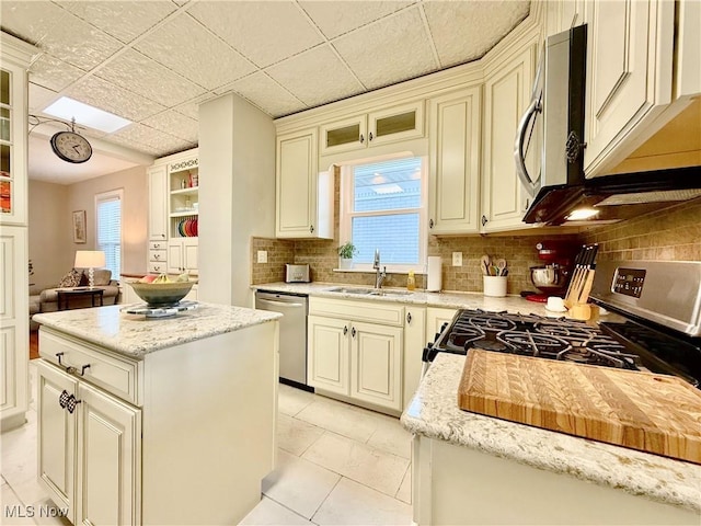 5519 4th Ave, Vienna, WV 26105 - kitchen featuring stainless steel appliances, decorative backsplash, a center island, and light stone countertops