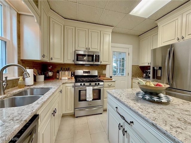 5519 4th Ave, Vienna, WV 26105 - kitchen featuring stainless steel appliances, decorative backsplash, light stone countertops, and light tile patterned floors