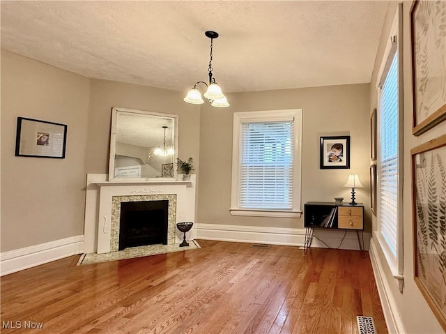 5519 4th Ave, Vienna, WV 26105 - living room featuring a chandelier, wood finished floors, a textured ceiling, and a fireplace