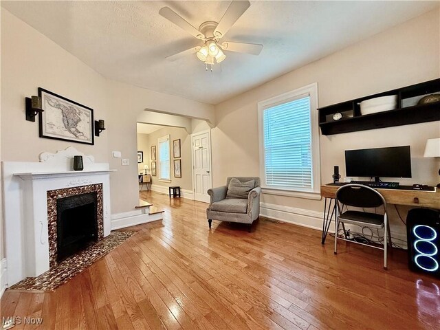 5519 4th Ave, Vienna, WV 26105 - living room featuring hardwood / wood-style floors, a ceiling fan, an office area, a premium fireplace, and arched walkways