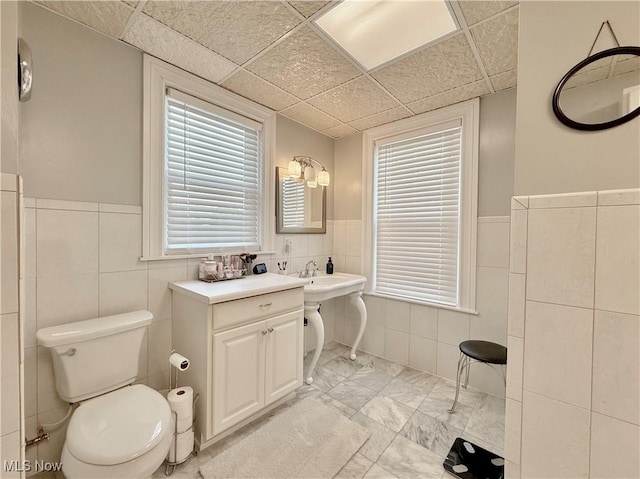 5519 4th Ave, Vienna, WV 26105 - bathroom featuring tile walls, wainscoting, and marble look tiles
