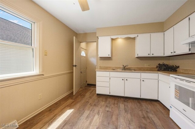 1586 Norledge Rd, Akron, OH 44305 - kitchen with white electric stove, white cabinets, light wood-style floors, a ceiling fan, and light countertops