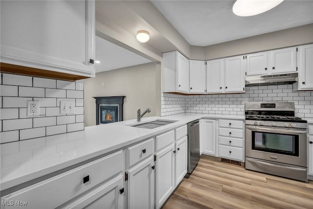 9543 Ridge Ct, Twinsburg, OH 44087 - kitchen with stainless steel appliances, under cabinet range hood, tasteful backsplash, and light countertops