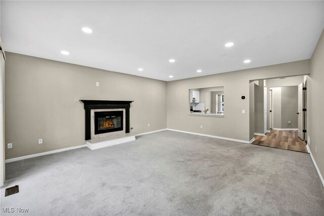 9543 Ridge Ct, Twinsburg, OH 44087 - unfurnished living room featuring carpet floors, a glass covered fireplace, and recessed lighting