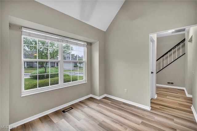 9543 Ridge Ct, Twinsburg, OH 44087 - unfurnished room with healthy amount of natural light, light wood-style floors, lofted ceiling, and stairway