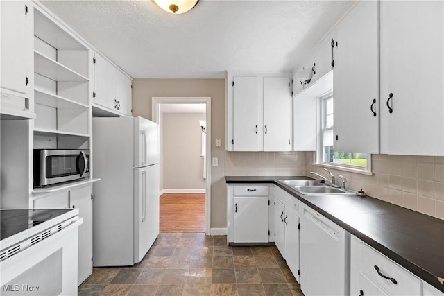 2016 Spring Ave NE, Canton, OH 44714 - kitchen featuring white appliances, white cabinets, decorative backsplash, and a textured ceiling