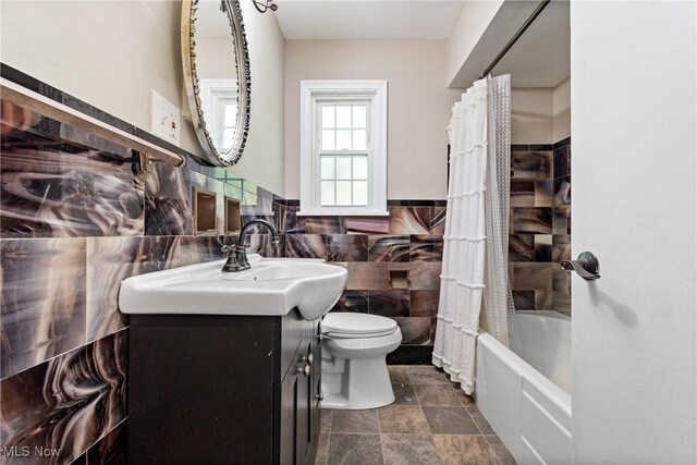 2016 Spring Ave NE, Canton, OH 44714 - full bathroom featuring vanity, tile walls, shower / bathtub combination with curtain, and a wainscoted wall