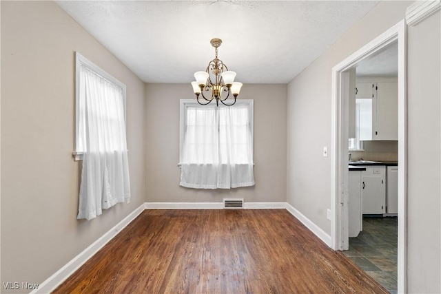 2016 Spring Ave NE, Canton, OH 44714 - unfurnished dining area with a chandelier and dark wood-style floors