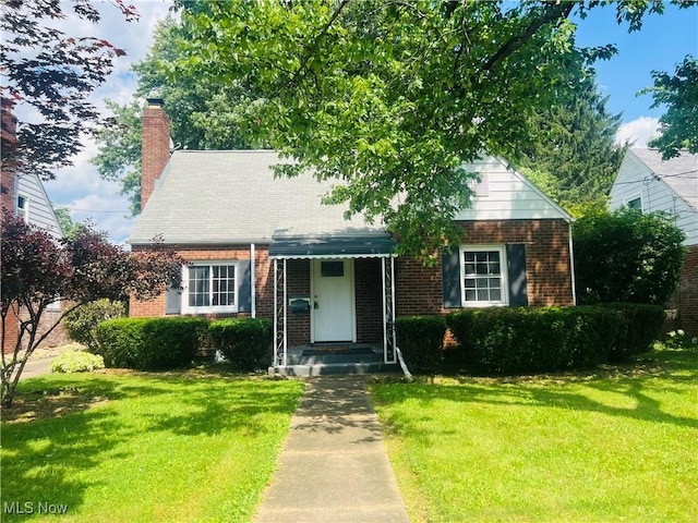 2016 Spring Ave NE, Canton, OH 44714 - cape cod-style house featuring brick siding, a front lawn, and a chimney