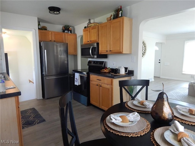 6012 Sunderland Dr, Parma, OH 44129 - kitchen featuring stainless steel appliances, light wood-style flooring, and arched walkways