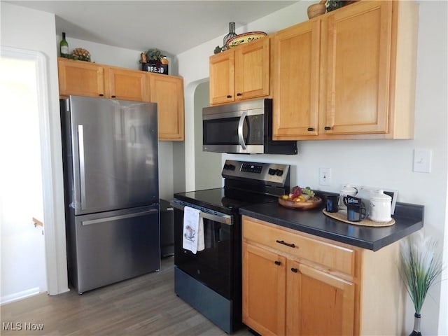 6012 Sunderland Dr, Parma, OH 44129 - kitchen with appliances with stainless steel finishes, wood finished floors, and dark countertops