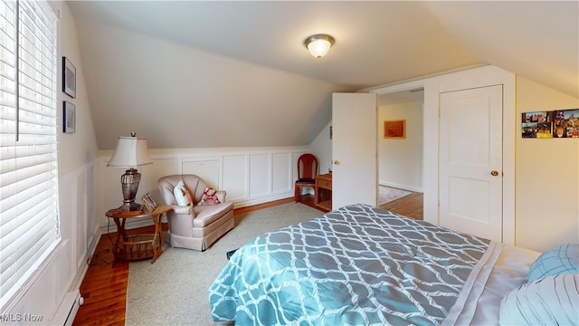 500 Elm St, Belpre, OH 45714 - bedroom featuring multiple windows, lofted ceiling, wood finished floors, and a baseboard heating unit