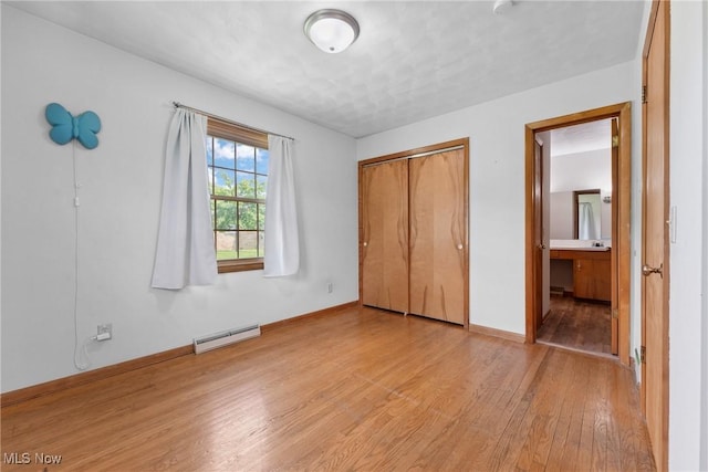 4130 Atwood Ave SE, Canton, OH 44707 - unfurnished bedroom with light wood-style floors, a baseboard radiator, and a closet