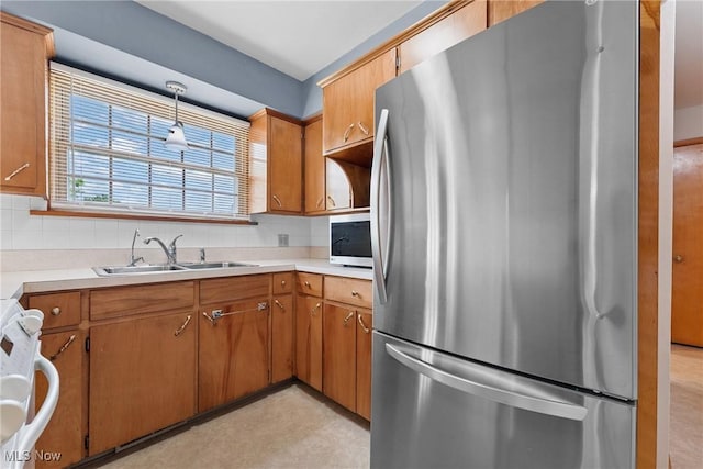 4130 Atwood Ave SE, Canton, OH 44707 - kitchen with appliances with stainless steel finishes, decorative backsplash, light countertops, and brown cabinetry