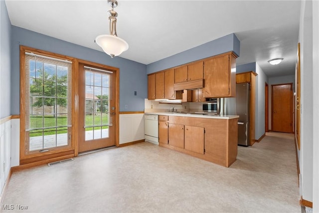 4130 Atwood Ave SE, Canton, OH 44707 - kitchen featuring light countertops, under cabinet range hood, a peninsula, white dishwasher, and pendant lighting