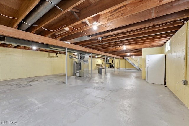 4130 Atwood Ave SE, Canton, OH 44707 - unfinished below grade area with freestanding refrigerator, heating unit, and concrete block wall