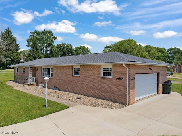 4130 Atwood Ave SE, Canton, OH 44707 - view of side of property featuring an attached garage, driveway, a lawn, and brick siding