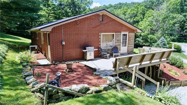 5882 Crooked Run Rd SW, New Philadelphia, OH 44663 - back of property featuring brick siding, a view of trees, and a patio area