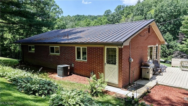5882 Crooked Run Rd SW, New Philadelphia, OH 44663 - view of property exterior featuring a standing seam roof, a wooden deck, brick siding, and a metal roof