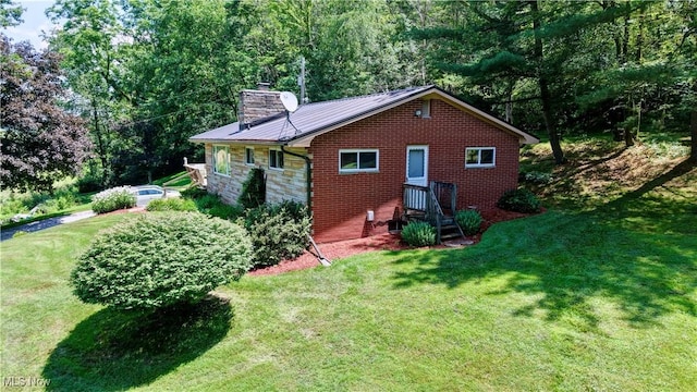 5882 Crooked Run Rd SW, New Philadelphia, OH 44663 - view of side of home featuring a chimney, a yard, a metal roof, a forest view, and brick siding