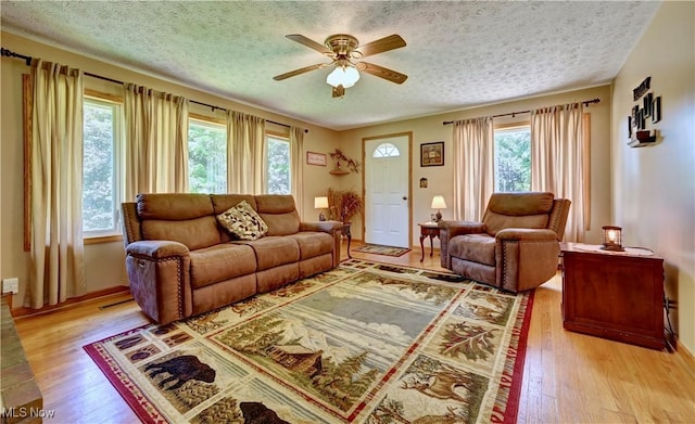5882 Crooked Run Rd SW, New Philadelphia, OH 44663 - living room with a textured ceiling, a ceiling fan, and light wood-style flooring