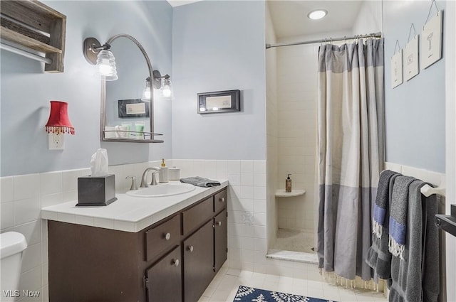 889 Eaton Ave, Akron, OH 44303 - full bathroom with tile walls, tile patterned flooring, vanity, a tile shower, and a wainscoted wall