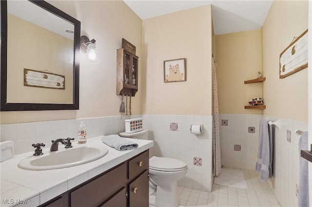 889 Eaton Ave, Akron, OH 44303 - bathroom with vanity, tile patterned floors, tile walls, a wainscoted wall, and a shower with curtain