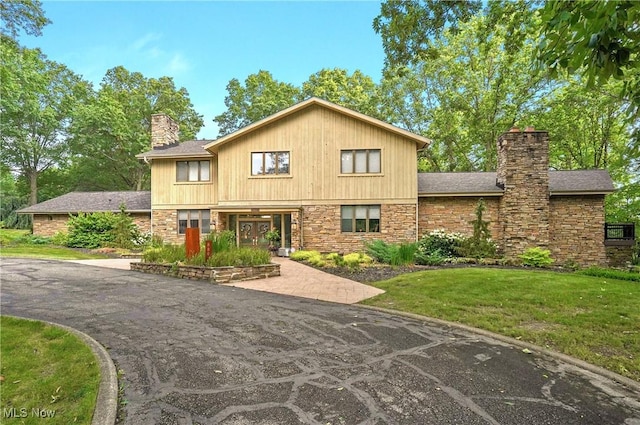889 Eaton Ave, Akron, OH 44303 - view of front of property featuring a chimney, stone siding, and a front lawn