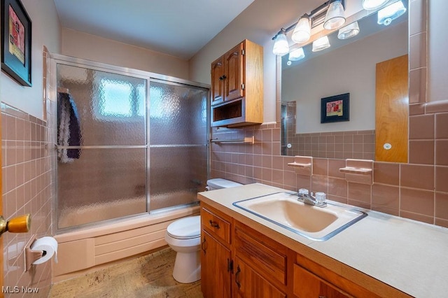3800 7th Ave, Vienna, WV 26105 - full bath with tile walls, vanity, shower / bath combination with glass door, wood finished floors, and tasteful backsplash