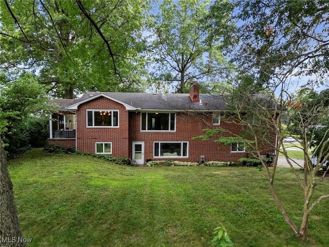 903 Robinson Ave, Barberton, OH 44203 - rear view of house with brick siding, a lawn, and a chimney
