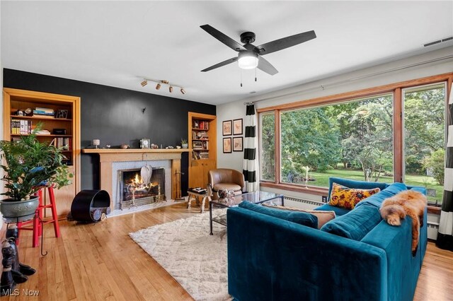 903 Robinson Ave, Barberton, OH 44203 - living room featuring a high end fireplace, ceiling fan, wood finished floors, baseboard heating, and rail lighting