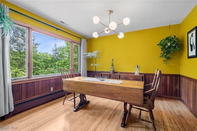 903 Robinson Ave, Barberton, OH 44203 - dining room with a wainscoted wall, a baseboard heating unit, a chandelier, wood finished floors, and wood walls