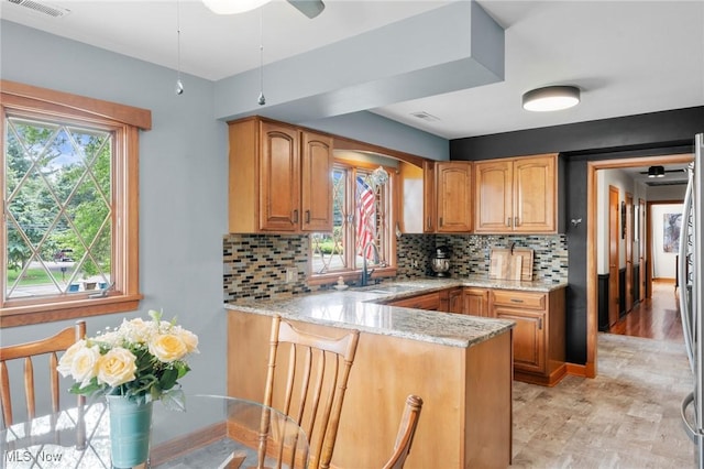 903 Robinson Ave, Barberton, OH 44203 - kitchen with light stone counters, a peninsula, plenty of natural light, and decorative backsplash