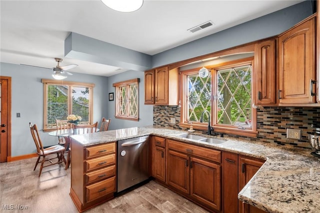 903 Robinson Ave, Barberton, OH 44203 - kitchen with dishwasher, a peninsula, tasteful backsplash, light wood-style flooring, and brown cabinetry