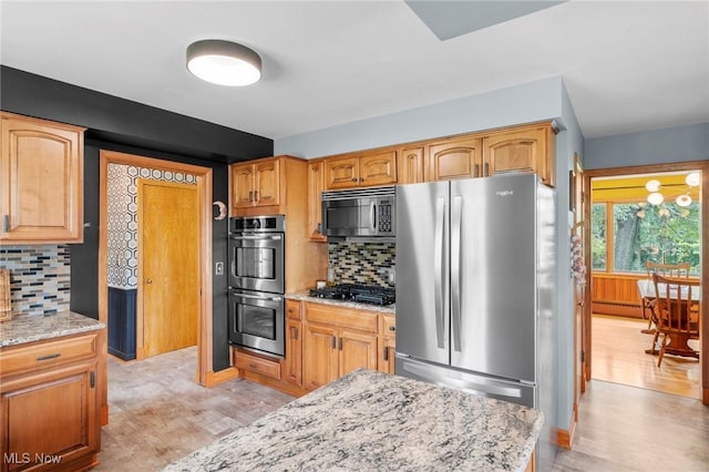 903 Robinson Ave, Barberton, OH 44203 - kitchen featuring stainless steel appliances, light wood finished floors, light stone counters, and decorative backsplash