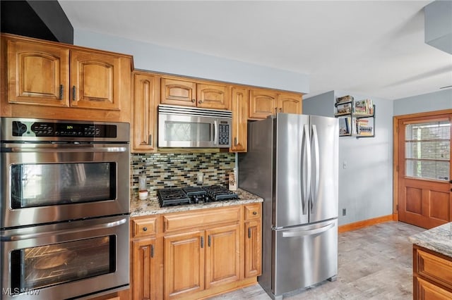 903 Robinson Ave, Barberton, OH 44203 - kitchen with appliances with stainless steel finishes, light stone countertops, backsplash, light wood finished floors, and brown cabinets