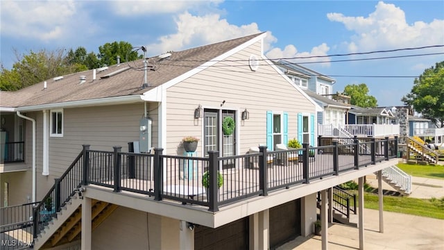 31 Anns Dr, Vienna, WV 26105 - rear view of house featuring stairs, a garage, a wooden deck, roof with shingles, and a patio