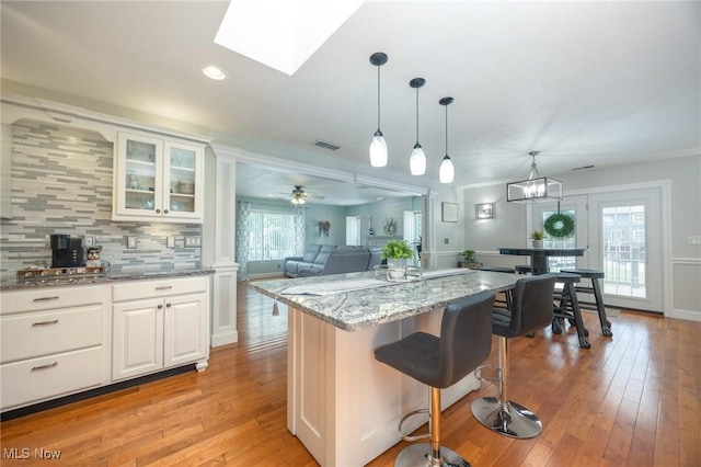 31 Anns Dr, Vienna, WV 26105 - kitchen with light stone countertops, light wood-style flooring, backsplash, a breakfast bar area, and recessed lighting