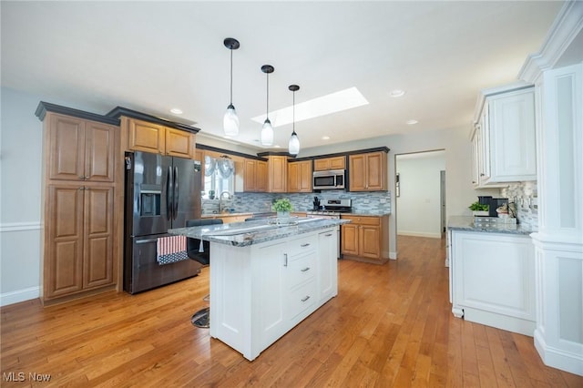 31 Anns Dr, Vienna, WV 26105 - kitchen with stainless steel appliances, tasteful backsplash, a skylight, light wood-style flooring, and recessed lighting