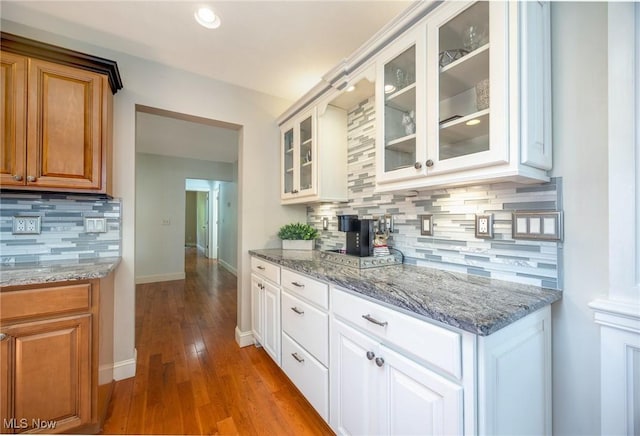 31 Anns Dr, Vienna, WV 26105 - kitchen with decorative backsplash, light stone countertops, glass insert cabinets, hardwood / wood-style flooring, and white cabinets