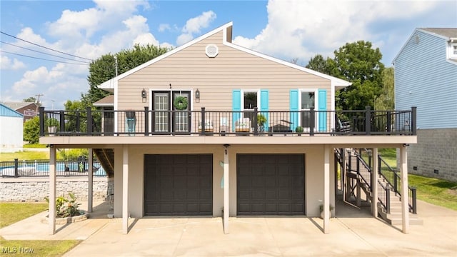 31 Anns Dr, Vienna, WV 26105 - rear view of house featuring stairway, an attached garage, driveway, and stucco siding