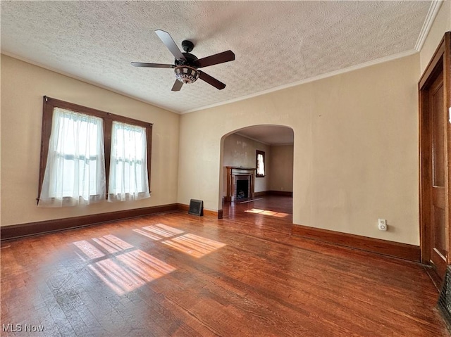 825 Summit St, Salem, OH 44460 - spare room with a textured ceiling, wood finished floors, a ceiling fan, arched walkways, and a fireplace