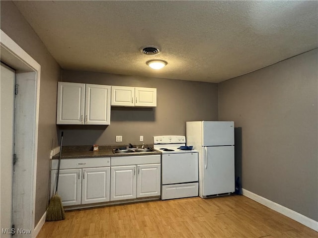 67 Neil Ann Dr, Parkersburg, WV 26101 - kitchen featuring white appliances, white cabinets, light wood-style flooring, dark countertops, and a textured ceiling
