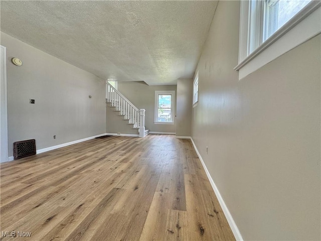 329 E Broad St, Newton Falls, OH 44444 - unfurnished living room featuring stairway, a textured ceiling, and light wood-style floors