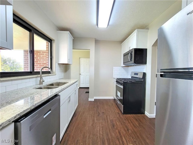 1006 Jackson Ave, Parkersburg, WV 26101 - kitchen with stainless steel appliances, dark wood-style flooring, white cabinetry, and light stone counters