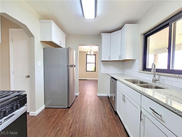 1006 Jackson Ave, Parkersburg, WV 26101 - kitchen with appliances with stainless steel finishes, white cabinets, decorative backsplash, and dark wood-type flooring